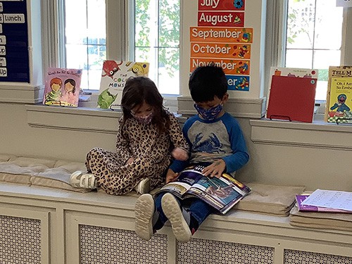 Two children reading a book together